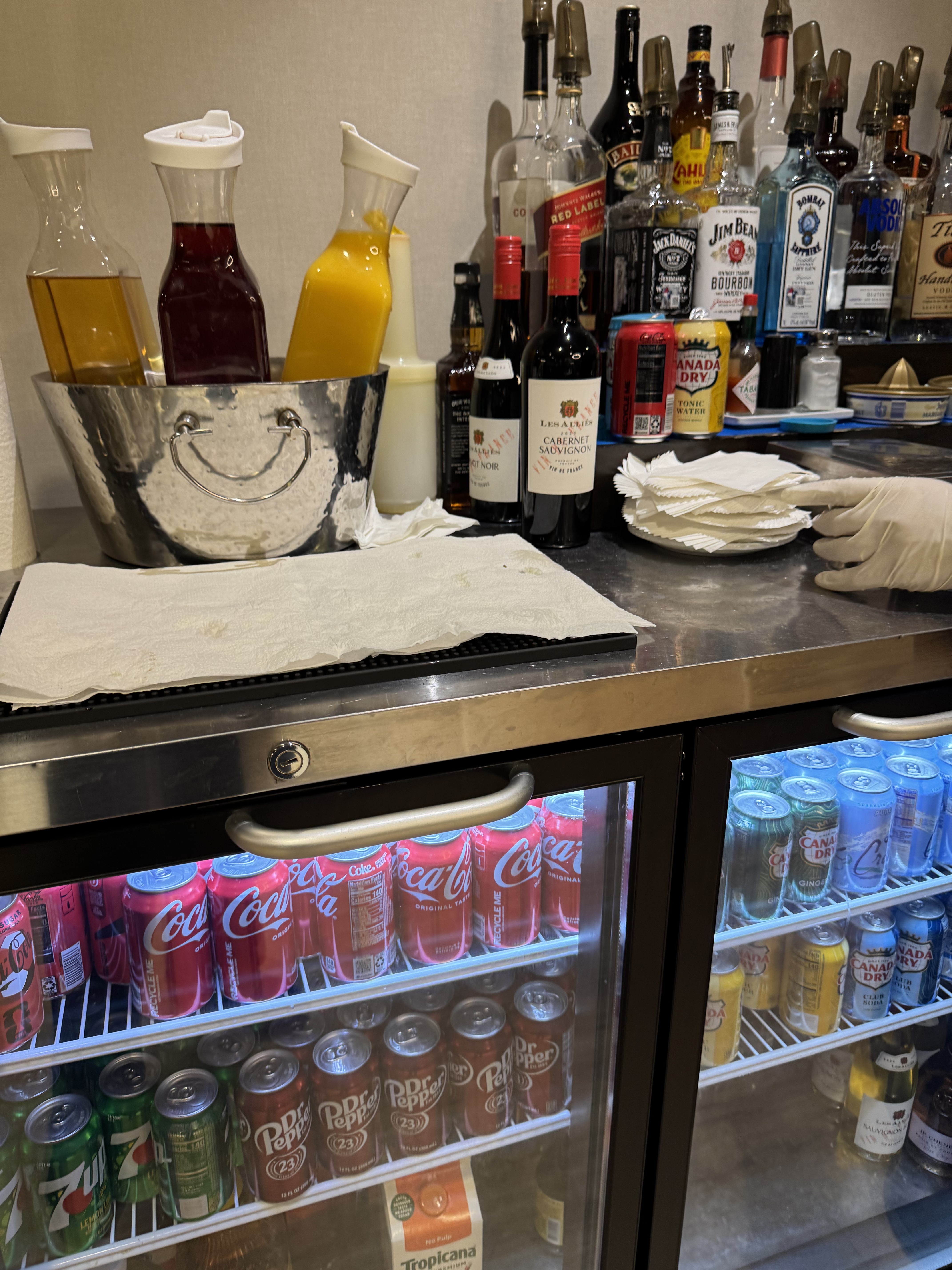 KLM Crown Lounge bar area with bartender and drink selection