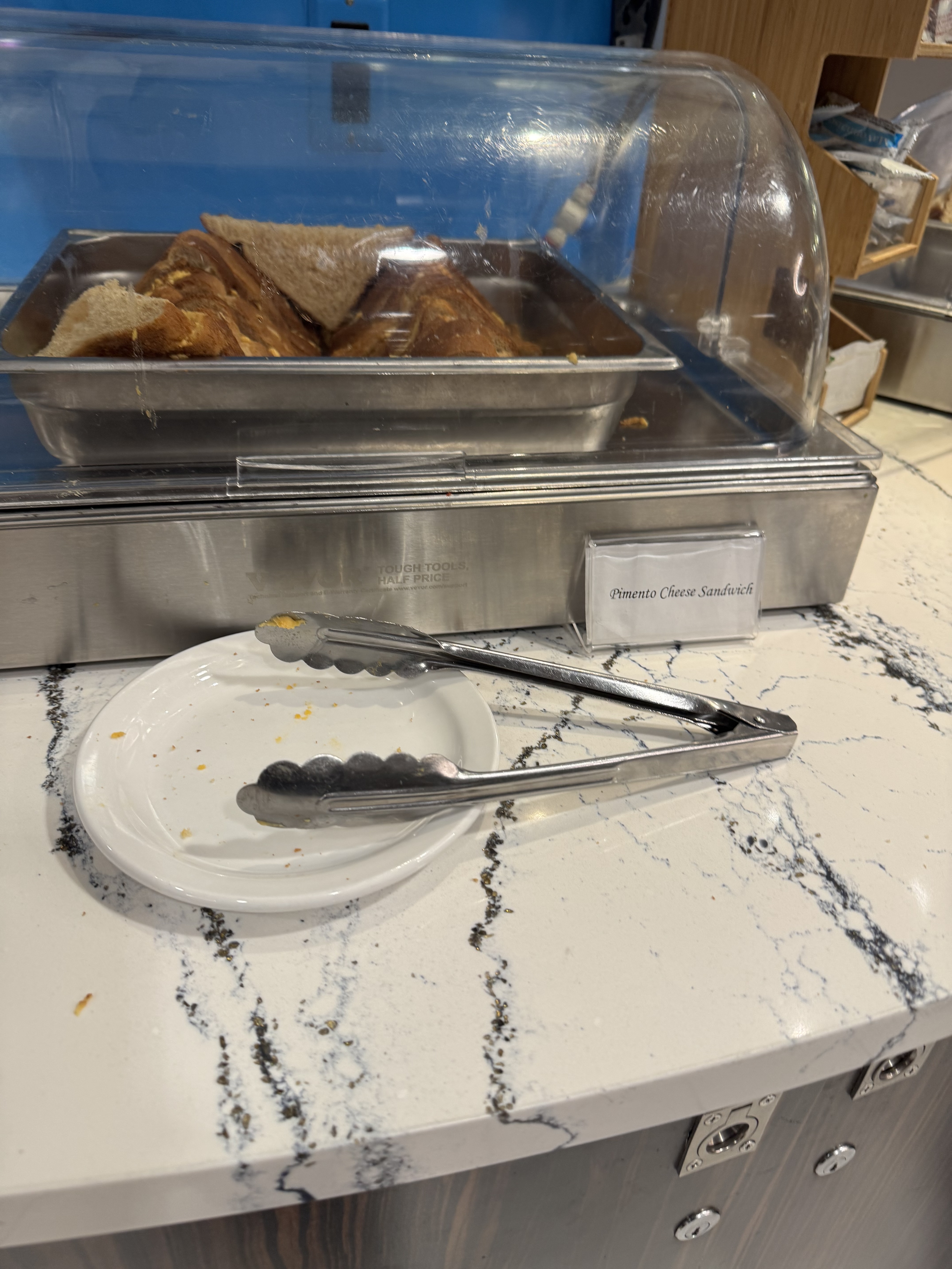 KLM Crown Lounge food selection showing sandwiches and snacks